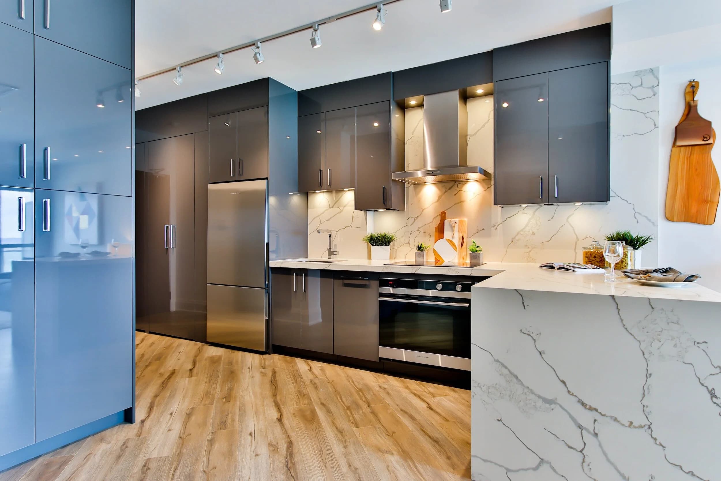 Striking navy-blue cabinetry kitchen with brass tapware and engineered stone tops